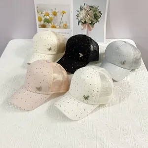 Flat lay of mesh baseball caps with sequins and metal butterfly details in five colors
