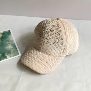 Détail de casquette en velours matelassé avec strass brillants en rose clair