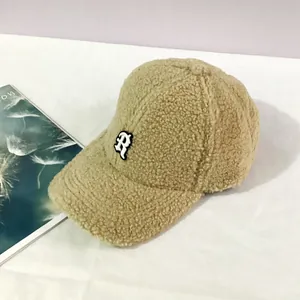 Detail of light khaki lamb wool baseball cap with thick texture and R embroidery