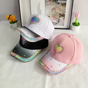 Detail of gradient heart sequin patch and rhinestone trim on fashion baseball caps
