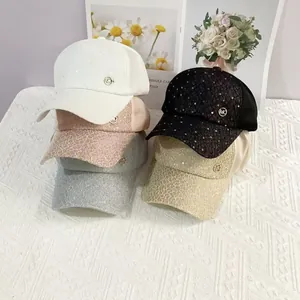Detailed view of fashionable lace baseball caps with sequins and metallic MC logo detail