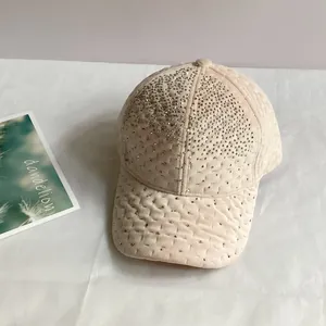 Détail de la casquette en velours avec strass brillants et motif matelassé à losanges