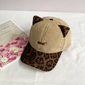 Detail of plush baseball cap with leopard print cat ears and 'new' embroidery