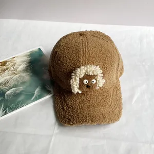 Détail de la casquette de baseball marron en polaire avec décor de mouton blanc mignon