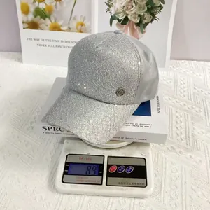 Close-up of lightweight lace baseball cap with sequins on a digital scale weighing 89g