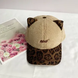 Detailed embroidery of 'new' letters on a beige plush cat ear baseball cap with leopard print