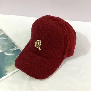 Detailed close-up of dark red sherpa baseball cap featuring a retro letter R embroidery