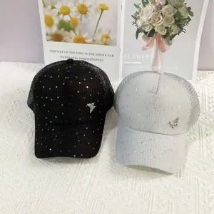 Close-up of mesh baseball caps with sequins and a rhinestone butterfly ornament