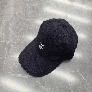 Detailansicht der schwarzen Fleece-Baseballkappe mit weißem Bären- und M-Stickerei