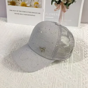 Detail of light gray mesh baseball cap with silver sequins and rhinestone butterfly