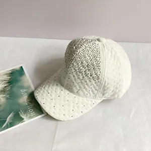 Détail d'une casquette en velours blanc ornée de strass argentés et texture losange