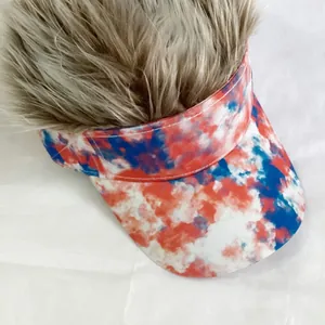 Close-up of tie-dye baseball hat with long light brown synthetic hair for funny parties