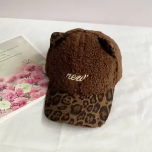 Detailed close-up of brown plush cat ear baseball cap with leopard print brim and embroidery