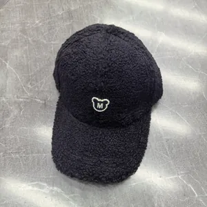Detail der schwarzen Fleece-Basecap mit Bären-Logo aus Perlen und dem Buchstaben M