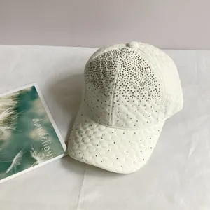 Détail d'une casquette en velours blanc avec motif matelassé et strass argentés brillants