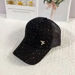 Detail of black mesh baseball cap with silver metal butterfly and sparkling sequins