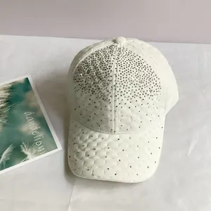 Détail d'une casquette de baseball en velours blanc matelassé avec des strass argentés