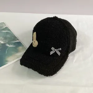 Détails de la casquette noire épaisse en laine d'agneau avec lapin et nœud décoratif