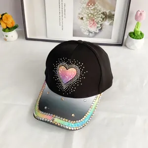 Close-up of heart-shaped pink sequins and rhinestones on a black baseball cap