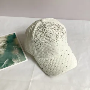 Détail d'une casquette de baseball en velours blanc ornée de strass argentés brillants