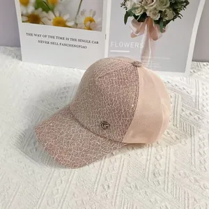 Detail of pink lace baseball cap with metal MC logo and breathable mesh back