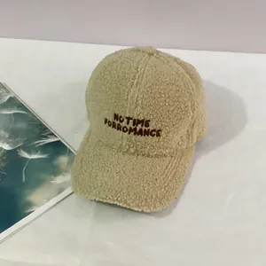 Close-up of beige fleece baseball cap featuring 'NO TIME FOR ROMANCE' brown embroidery