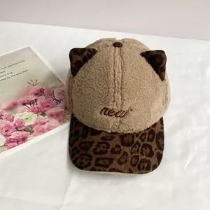 Close-up of beige plush baseball cap with leopard print cat ears and new embroidery