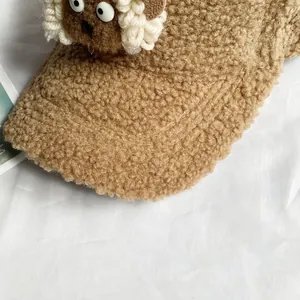 Détail de la casquette de baseball en laine d'agneau marron avec yeux de mouton mignons