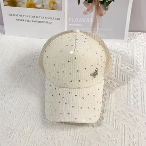 Detail of cream baseball cap with gold sequins, 3D metal butterfly and breathable mesh