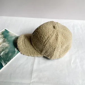 Detailansicht der beigen Lammfell-Baseballkappe mit weicher Textur und Seitenstickerei