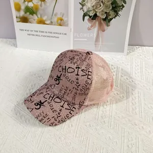 Detail of pink glitter baseball cap with black graffiti letters and breathable mesh back