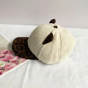 Detail of plush baseball cap featuring white faux fur and leopard print cat ears