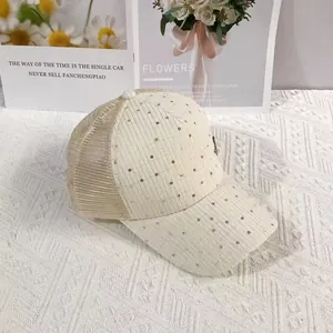 Detail of beige summer mesh baseball cap featuring shimmering sequins and breathable mesh