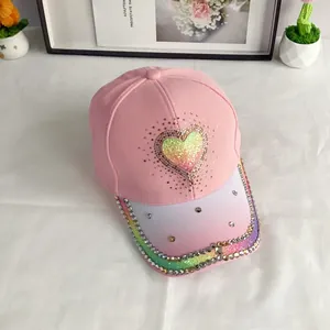 Close-up of pink baseball cap featuring gradient glitter heart and rainbow sequin brim with rhinestones