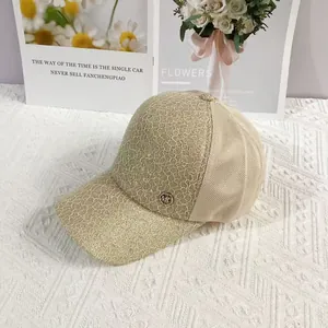 Detail of elegant beige lace embroidery and MC metal logo on a breathable baseball cap