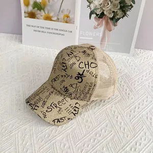 Close-up of golden glitter mesh baseball cap with black graffiti letters and metal M detail