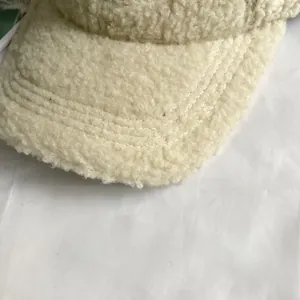 Detailed macro view of beige sherpa baseball cap brim with three neat parallel stitches