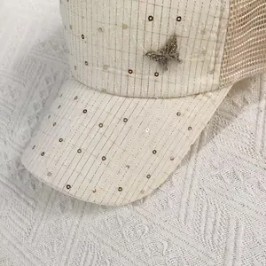 Close-up of mesh baseball cap with silver butterfly buckle and sparkling sequins