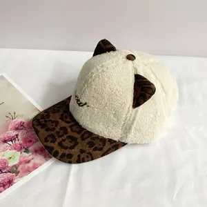 Detailed view of plush cream faux fur texture and leopard print cat ears on baseball cap