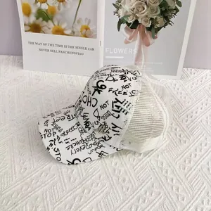 Detailed close-up of hip-hop baseball cap featuring black graffiti on white mesh fabric
