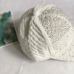 Détail de la casquette de baseball blanche en velours avec texture et strass étincelants