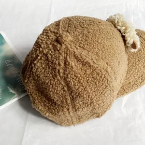 Texture détaillée d'une casquette en polaire marron avec oreilles et bouton supérieur