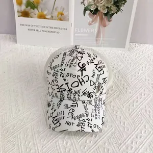 Detailed view of white hip-hop trucker hat featuring black graffiti print and breathable mesh
