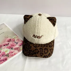 Detail of plush baseball cap with cute leopard print cat ears and 'new' embroidery