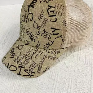 Detail of gold glitter baseball cap featuring black graffiti text and breathable mesh back