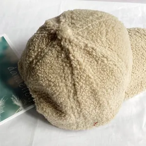 Dettaglio della trama in pile beige su un berretto da baseball invernale caldo