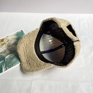 Dettaglio della trama in pile beige e del design minimalista del berretto invernale