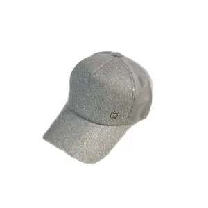 Chic light gray lace baseball cap with sparkling sequins and circular metal MC logo badge