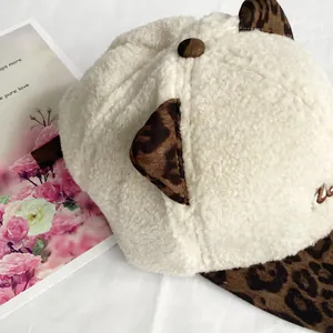 Detailed close-up of white sherpa baseball cap with leopard print ears and brim