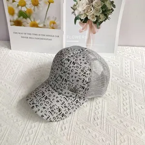 Close-up of silver glitter mesh baseball cap with gold metal plate and letter printing